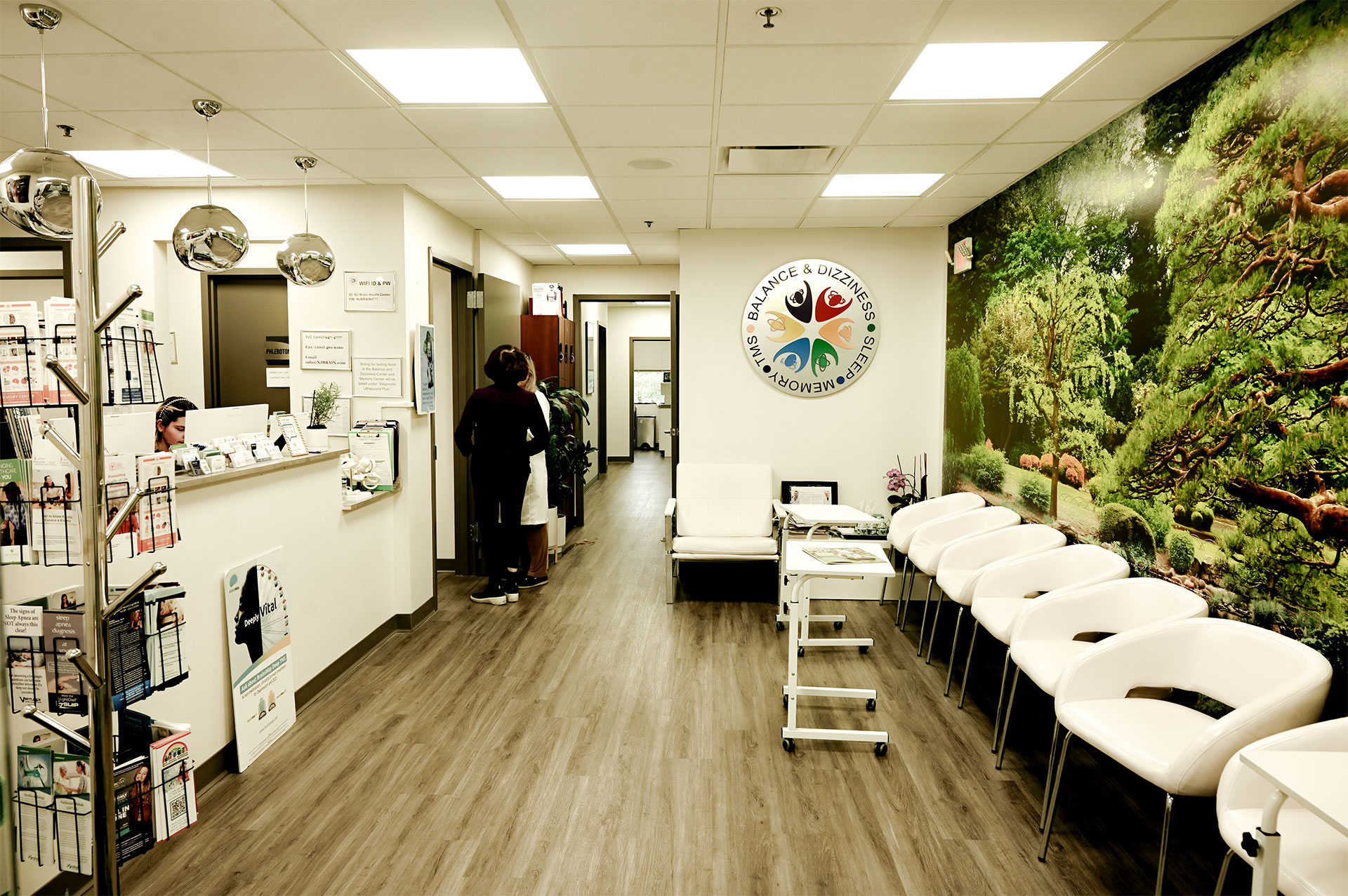 The image depicts an interior space with a pharmacy counter and a waiting area, featuring a colorful mural on the wall behind the counter.